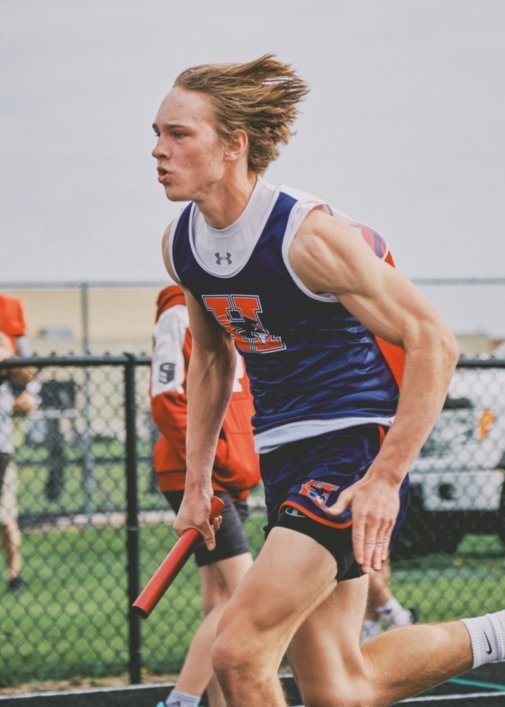 Sophomore Braden Walter runs with the baton in a relay event for the Heritage track team.